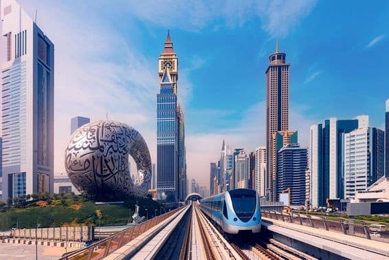 دبئی میٹرو پیچھے بلند عمارتوں کے ساتھ، بائیں جانب مستقبل کا میوزیم۔
