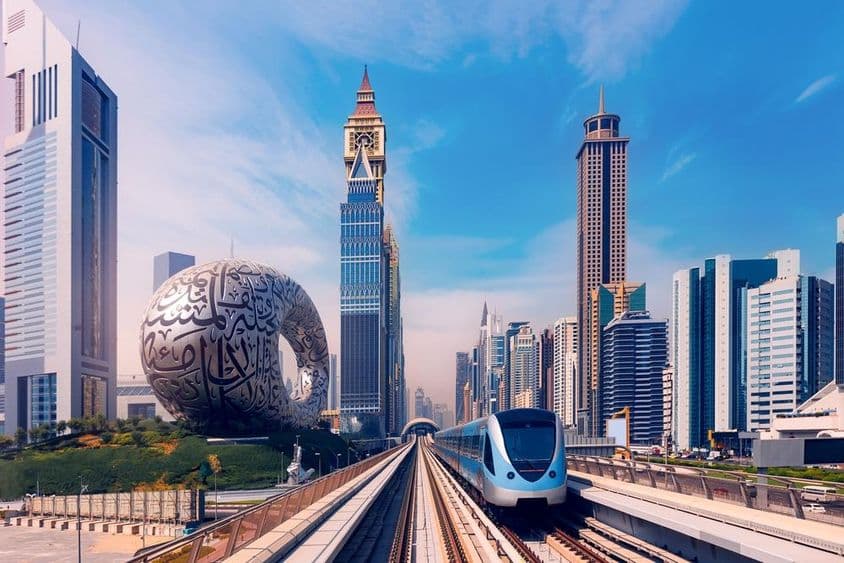 دبئی میٹرو پیچھے بلند عمارتوں کے ساتھ، بائیں جانب مستقبل کا میوزیم۔