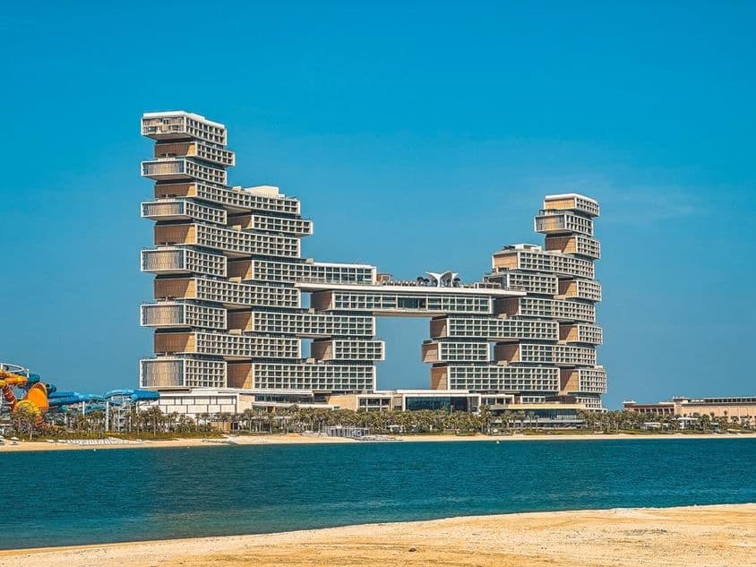 پس منظر میں اٹلانٹس دی رائل ہوٹل کے ساتھ پانی اور ساحل سمندر