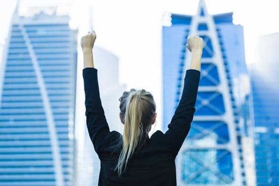 ایک خاتون کا ہاتھ بلند، پیچھے فلک بوس عمارتیں