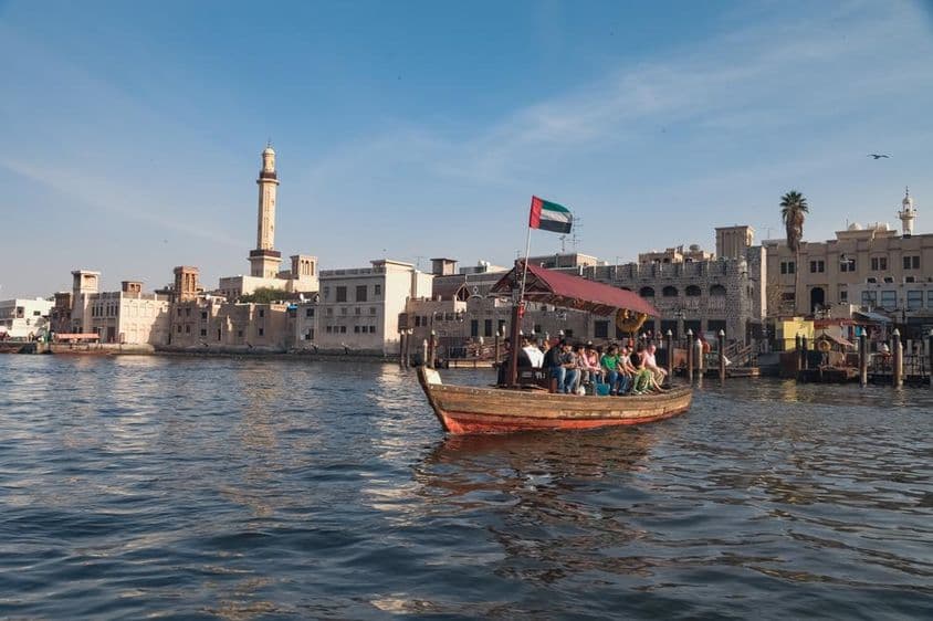 دبئی کی ابرا کشتی پر بیٹھے لوگ۔