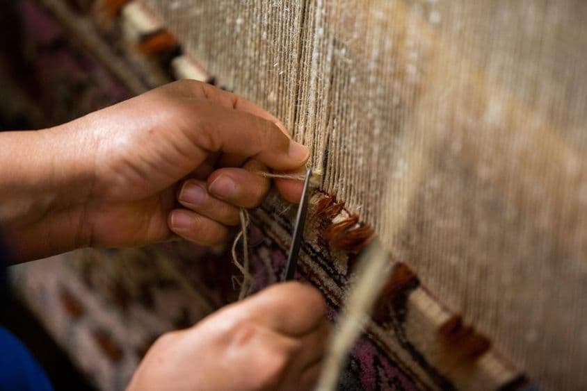 فارسی قالین ہاتھ سے بناتے وقت۔