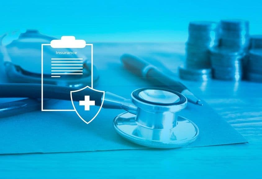 صحت کی انشورنس، پس منظر میں سٹیتھسکوپ اور چھوٹی کرنسی