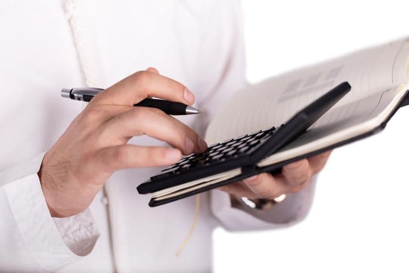 ہاتھ کی مدد سے نوٹ پیڈ پر کیلیکیولیٹر کو استعمال کیا جا رہا ہے۔