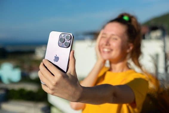 نوجوان لڑکی آئی فون فون پکڑے ہوئے۔