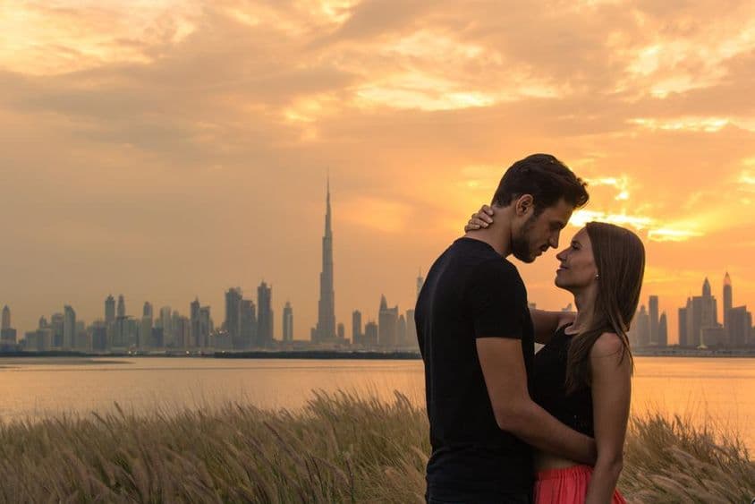 دوبئی کے منظر کے ساتھ ایک نوجوان جوڑا۔