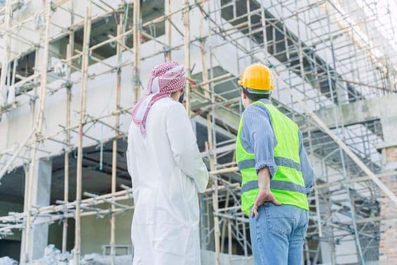 انجینئر اور سرمایہ کار زیر تعمیر عمارت کو دیکھتے ہوئے