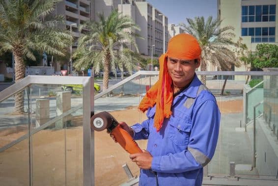 دبئی میں ایک مزدور ریلنگ کو پالش کر رہا ہے۔