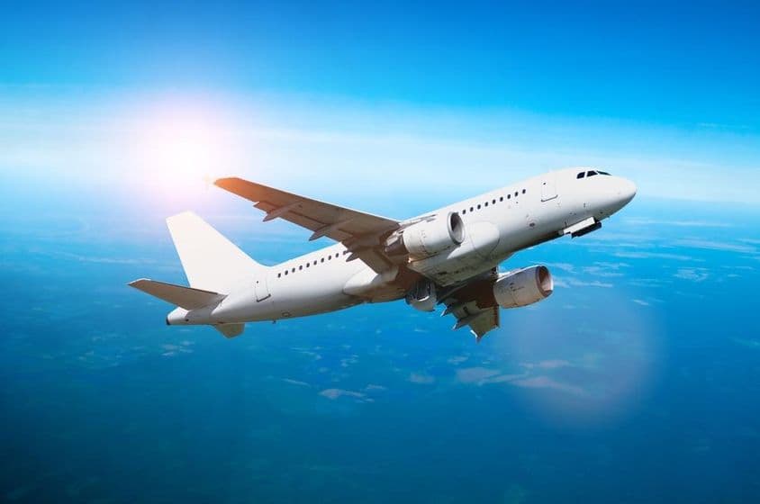 آسمان میں پرواز کرتا ہوا سفید طیارہ۔