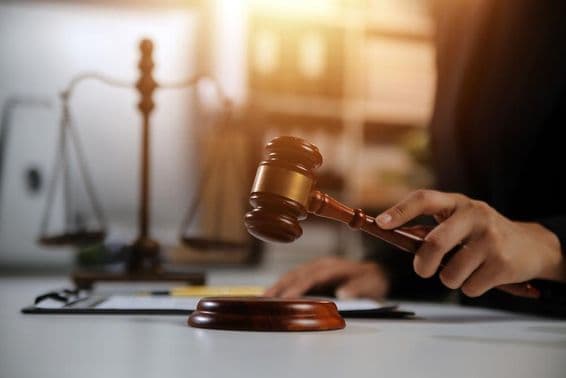جج کے ہاتھ میں ہتھوڑا، پس منظر میں میزان