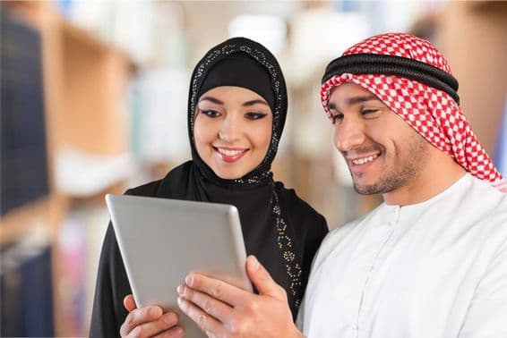 عربی کے طلبہ ایک ٹیبلٹ پر تعلیمی مواد دیکھ رہے ہیں۔