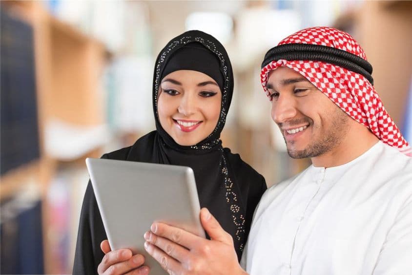 عربی کے طلبہ ایک ٹیبلٹ پر تعلیمی مواد دیکھ رہے ہیں۔