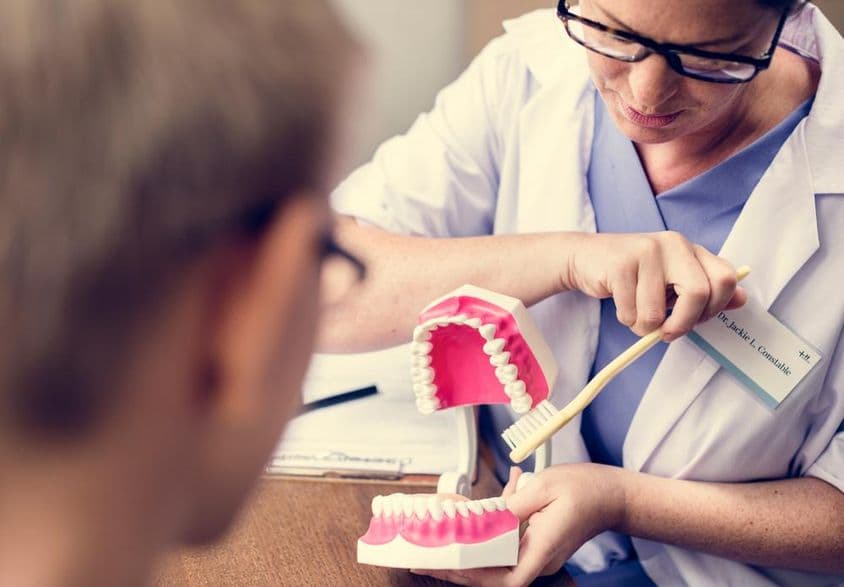 دبئی میں دندان ساز دانتوں کی صفائی سکھا رہا ہے۔