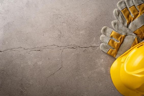 وقفے کا وقت، پیلی ہیلمٹ اور کام کے دستانے ایک پھٹے ہوئے کنکریٹ کی سطح پر رکھے ہوئے۔