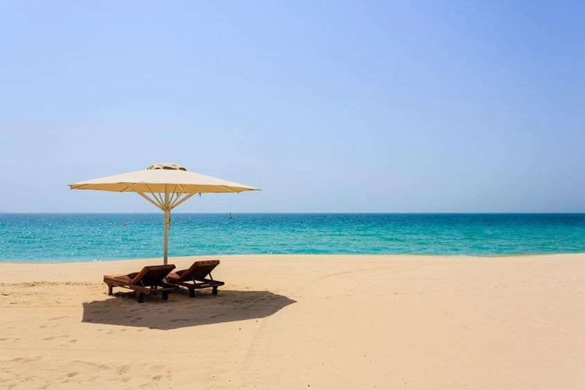 دبئی کے جمیرا بیچ پر ریتلی ساحل پر دھوپ لینے کی کرسیاں۔