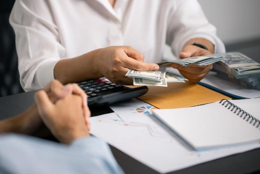 ایک شخص دانشمندی سے مالیات کی انتظامی، تنخواہ سے نقدی بچا رہا ہے، مستقبل کی ادائیگیوں اور کاروباری سرمایہ کاری کے لئے مستحکم آمدنی کو یقینی بناتے ہوئے۔