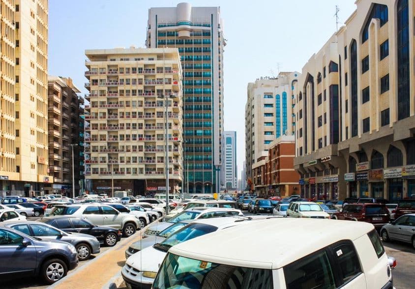 ابوظہبی کے اسکائی لائن اور ابوظہبی میں پارک کی گئی گاڑیوں کا منظر