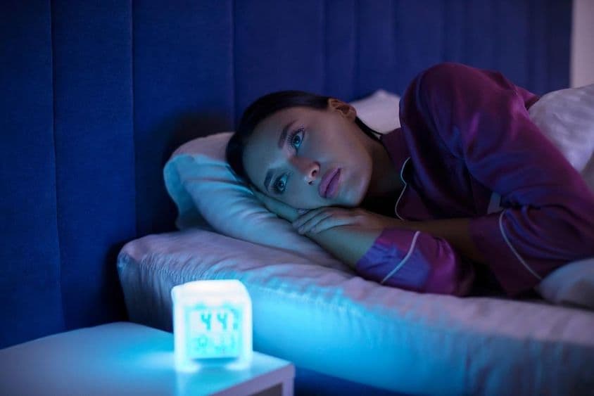 اداس بے خوابی خاتون بستر پر لیٹی ہوئی، دور کہیں دیکھ رہی، سو نہیں پاتی، بے خوابی کی شکار۔