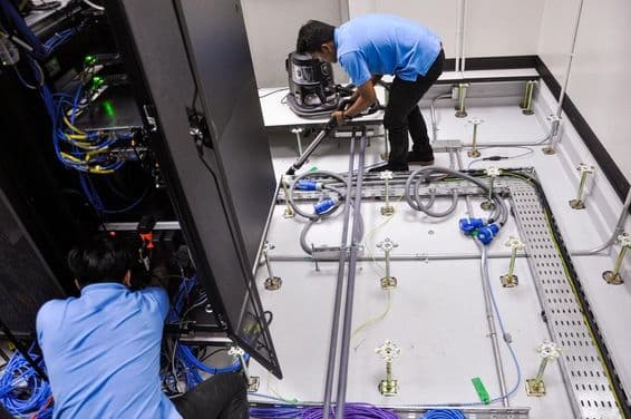 ورکرز ایک سرور روم کی تعمیر کر رہے ہیں، اٹھائی گئی فرش اور ریک کیبینٹس۔