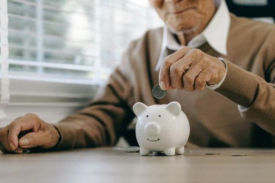 پیسے بچانا، بزرگ آدمی سکے پیگی بینک میں ڈال رہا ہے