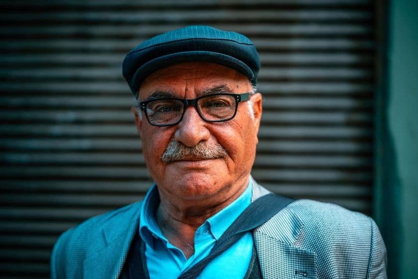 سڑک پر ٹوپی پہنے بزرگ آدمی۔