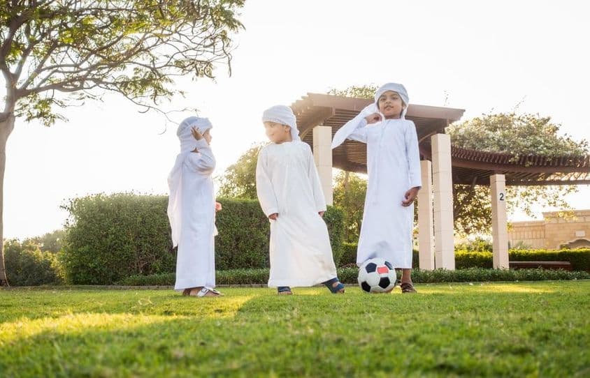 ایک گروپ میں مشرق وسطیٰ کے بچے باہر کھیل رہے ہیں اور مزہ کر رہے ہیں۔