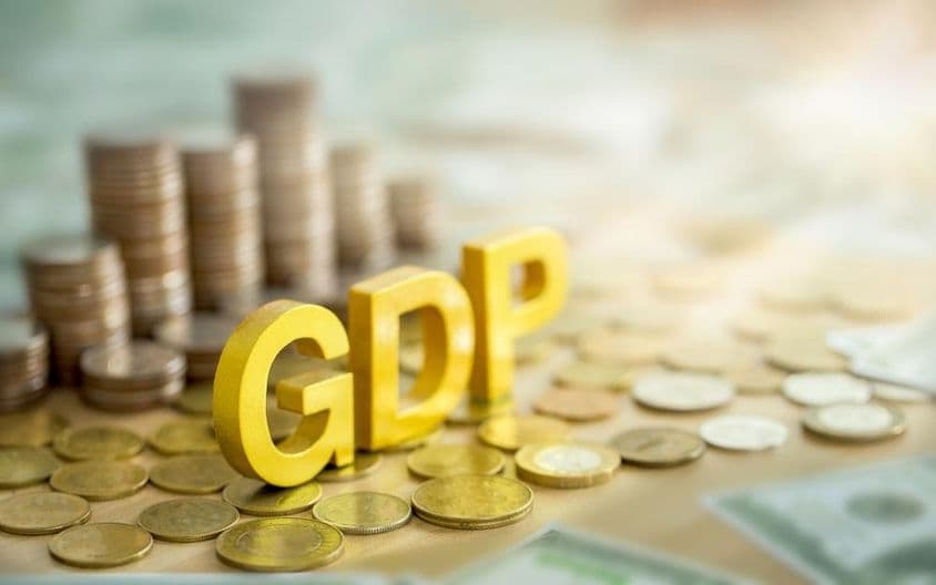جی ڈی پی عبارت کے ساتھ، پس منظر میں سکوں کا ڈھیر