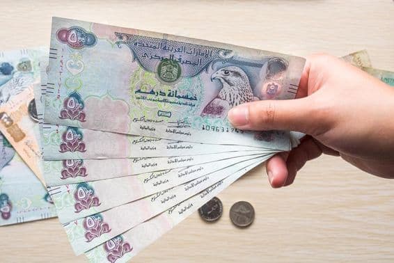 ایک لڑکی 500 یو اے ای درہم کے نوٹ پکڑے ہوئے، کاغذی کرنسی۔