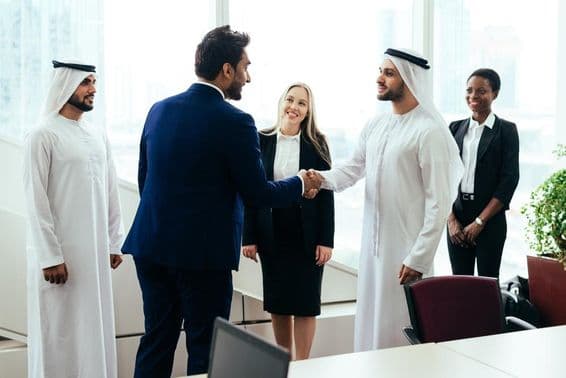 دبئی کے دفتر میں مل کر کام کرتی ہوئی مغربی اور مشرق وسطٰیی کاروباری ٹیم۔