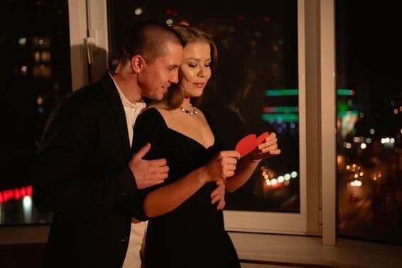 ویلنٹائن ڈے کی تاریخ پر کھڑکی کے پاس کھڑا محبت کرنے والا جوڑا۔