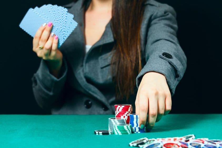 کسینو میں بلیک جیک، ایک عورت چپس کے ساتھ داؤ لگاتی ہے۔