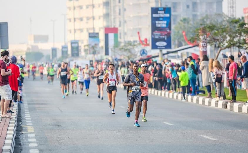 ہاف میراتھن کے دوران راستے پر دوڑنے والے اور جیتنے والے افراد