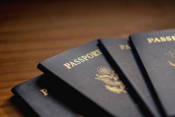 پاسپورٹس ایک لکڑی کی میز پر ایک دوسرے پر رکھے ہوئے ہیں۔