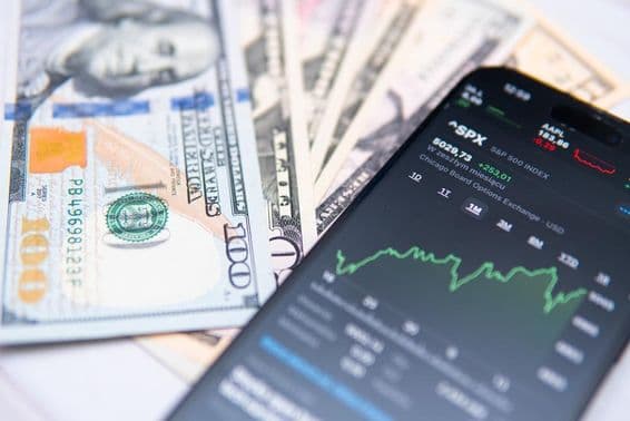ایس پی 500 انڈیکس اسمارٹ فون اسکرین پر، امریکی ڈالر کے پس منظر کے ساتھ