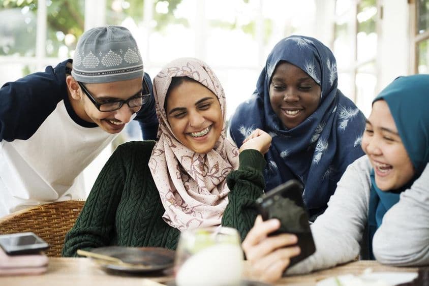 طلباء کی ایک گروپ موبائل فون پر سبق دیکھ رہی ہے۔