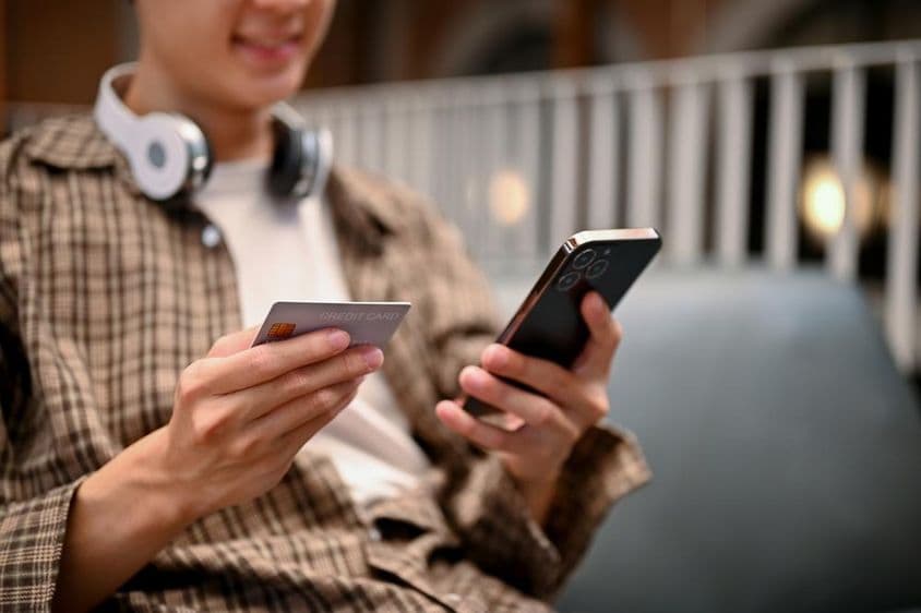 ایک ایشیائی شخص آن لائن شاپنگ ایپ پر کریڈٹ کارڈ کی ادائیگی کر رہا ہے۔