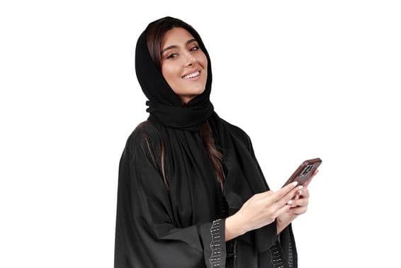 عرب عبایا میں موبائل فون پر کام کرنے والی اماراتی کاروباری خاتون۔