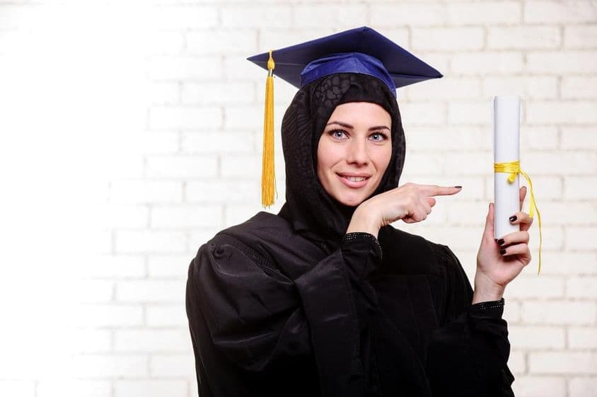 اندرونی مقام پر ڈپلومہ کے ساتھ مسکراتی ہوئی مسلمان گریجویٹ