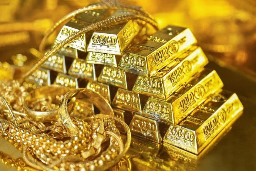 روشن پس منظر پر سونے کی اینٹیں اور زیورات
