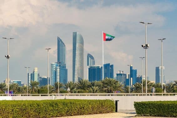ابو ظہبی کی مشہور افق جس میں جدید بلند عمارت اور نمایاں قومی جھنڈا نظر آ رہا ہے۔