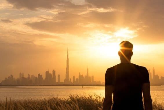 غروب آفتاب کے وقت ایک شخص شہر کے خوبصورت منظر کو دیکھ رہا ہے۔