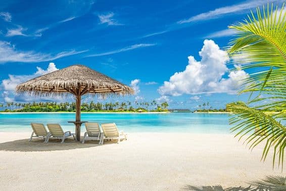 مالدیپ کا ریتیلا ساحل، چھتری اور ڈیک کرسی کے ساتھ۔