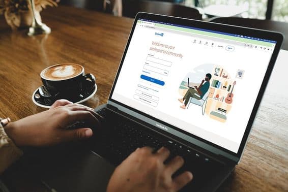 میک بک پر لنکڈاِن لاگ ان صفحہ کھولنے والا شخص۔