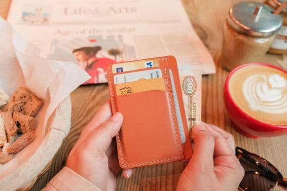 بھورے چمڑے کا کارڈ ہولڈر جس میں شناختی کارڈز، بنک کارڈز، اور کریڈٹ کارڈز موجود ہیں۔