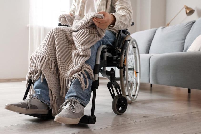 گھر میں ویل چیئر پر موجود نوجوان شخص۔
