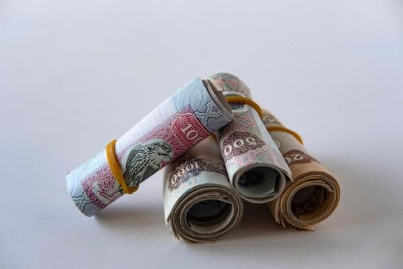 متحدہ عرب امارات کے درہم کرنسی اور سکے کا مجموعہ لپیٹا ہوا اور ڈھیر میں رکھا ہوا۔