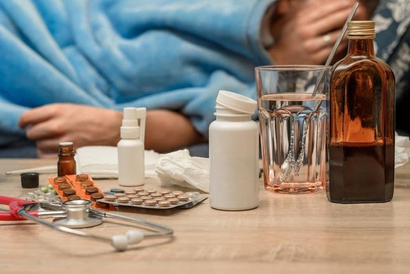 ایک آدمی زکام اور بخار کے ساتھ بستر میں لیٹا ہوا۔