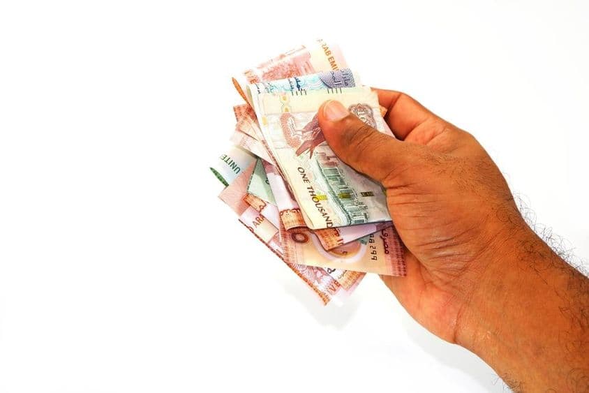 ہاتھ میں پکڑے ہوئے درہم کے نوٹ۔