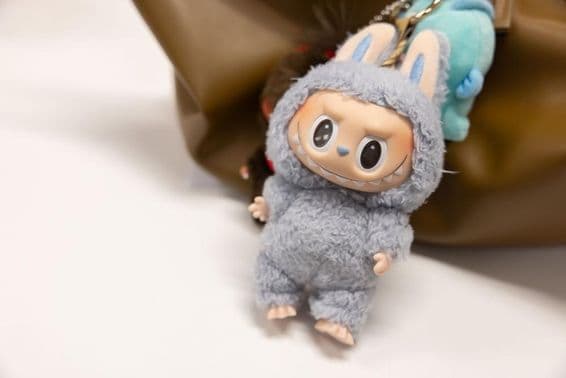 ایک عورت کے بیگ پر مشہور پاپمارٹ لیبُوبو کی تصویر