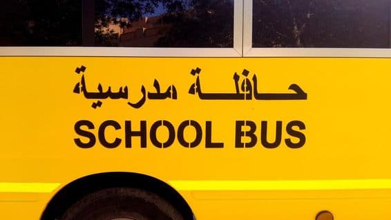 عربی میں اسکول بس لکھی ہوئی ایک بس کا اطراف